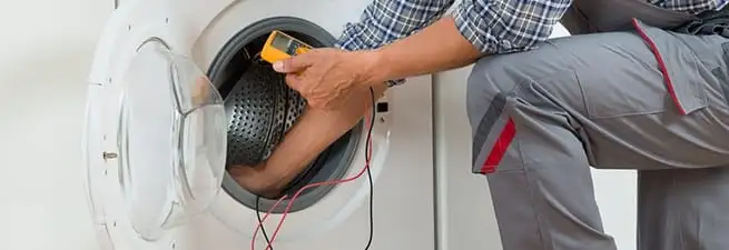 Dryer repair technician inspecting and repairing a clothes dryer in Gilbert, AZ
