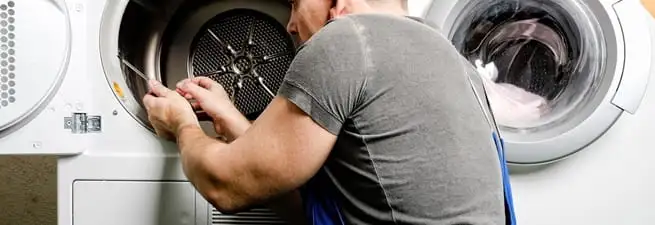 Dryer repair technician fixing a clothes dryer drum in Gilbert, AZ