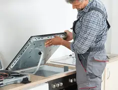 Appliance repair technician installing a built-in cooktop in Gilbert, AZ