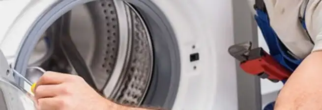 Appliance technician repairing a clothes dryer drum and internal parts in Gilbert, AZ