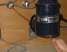 Garbage disposal repair technician tightening the mounting ring under a sink in Gilbert, AZ