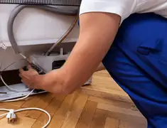 Appliance repair technician fixing refrigerator water line and connections in Gilbert, AZ
