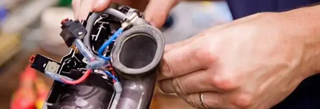 Vacuum repair technician reconnecting wiring and components in Gilbert, AZ