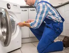 Washing machine repair technician servicing a front-load washer in Gilbert, AZ