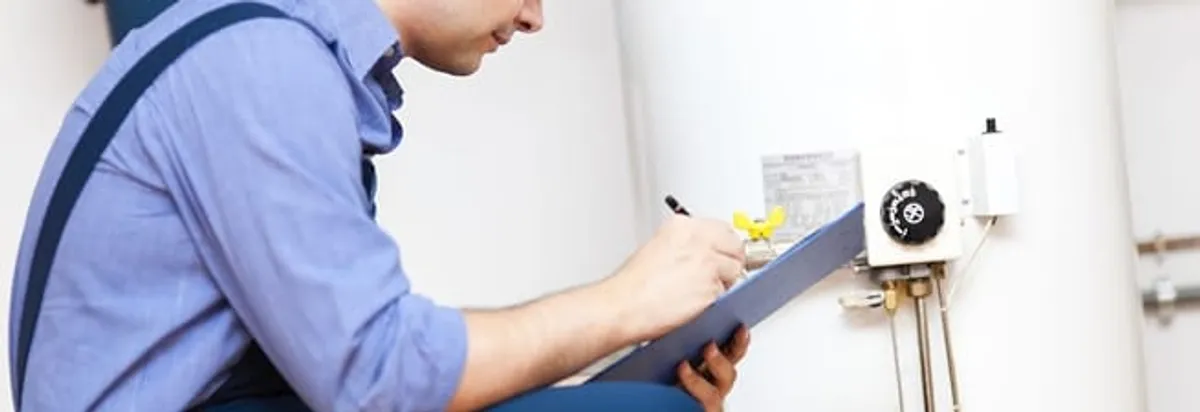 Water heater repair technician inspecting the unit and recording service notes in Gilbert, AZ