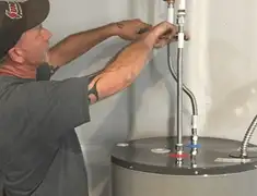 Water heater repair technician tightening supply line connections in Gilbert, AZ